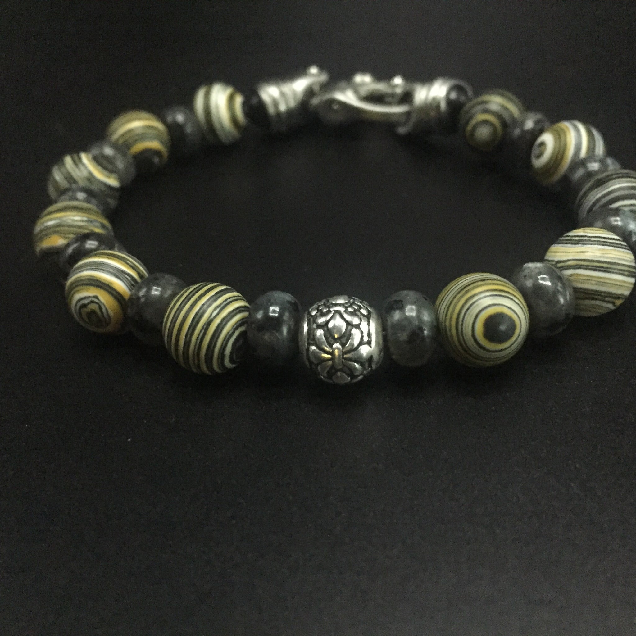 Yellow Malachite and gray Labradorite with a sterling silver center filagree bead and stainless steel clasp.